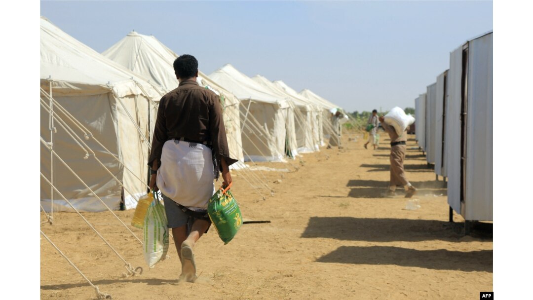 FILE - Displaced Yemenis return to their tents with aid donated by a Kuwaiti charitable organization on the outskirts of the northeastern city of Marib, on Jan. 1, 2022
