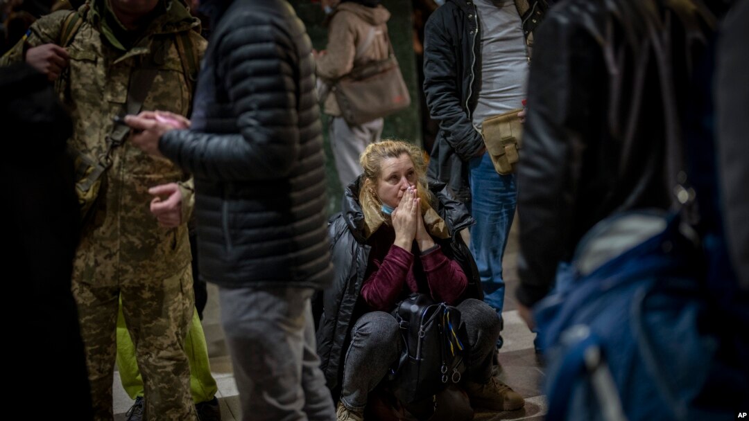 A woman reacts as she waits for a train trying to leave Kyiv, Feb. 24, 2022, as Russia launched its invasion of Ukraine.