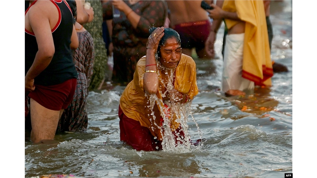 A pilgrim takes a holy dip in the confluence of the Ganges and Yamuna rivers during the Maha Kumbh Mela festival in Prayagraj, India, on Feb. 12, 2025.