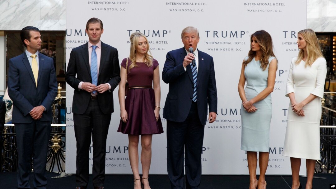 FILE - Then-candidate Donald Trump, accompanied by his family, speaks during the grand opening of the Trump International Hotel-Old Post Office, Washington, Oct. 26, 2016. Experts on government ethics are warning President-elect Trump that he’ll never shake suspicions of a clash between his private interests and the public good if he doesn’t sell off his vast holdings.