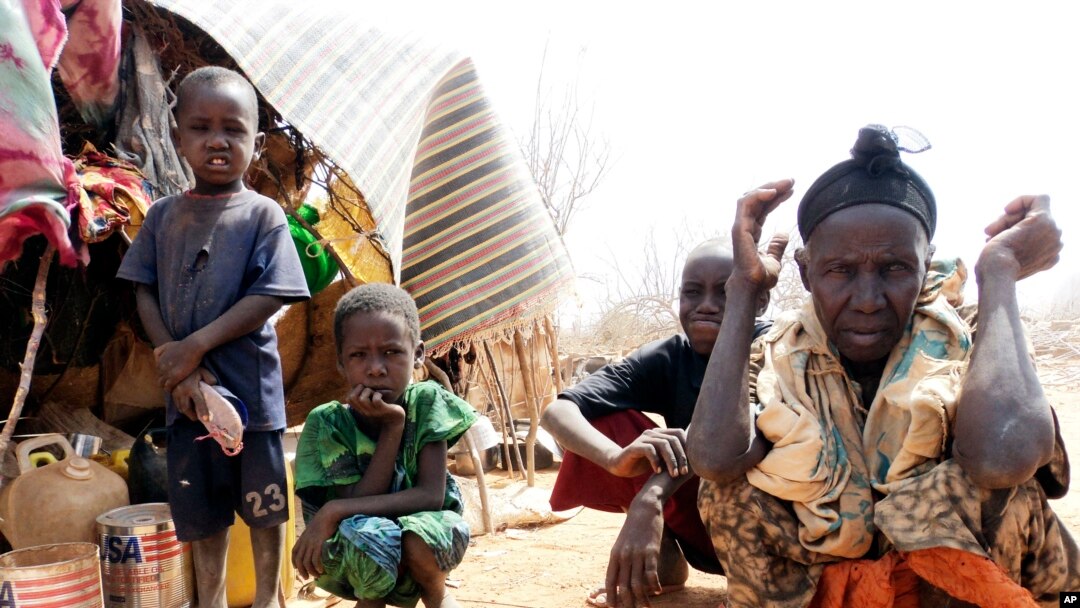 FILE - Refugees sit outside in an open area as there is lack of tents at the Dollo Ado refugee camp, Ethiopia.
