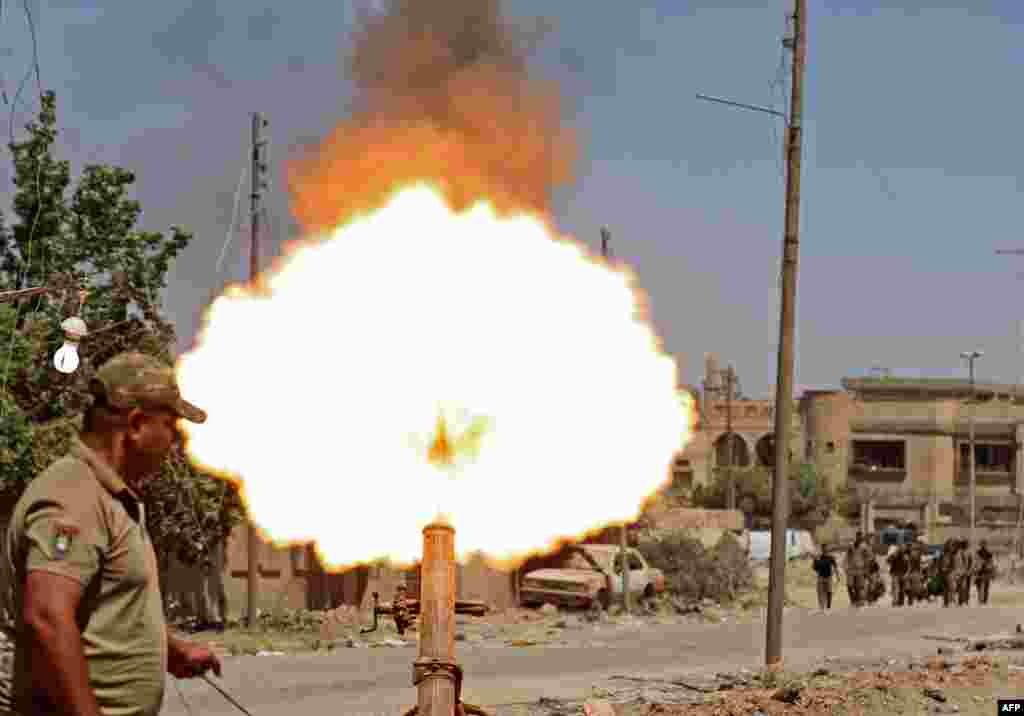Members of the Iraqi forces fire mortar shells during battles in western Mosul's Zanjili neighbourhoodm, as government forces advance in the area during their ongoing battle against Islamic State (IS) group fighters.