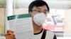 Passenger Kevin Ouyan shows an information pamphlet he was given on arrival at Sydney airport in Sydney, Jan. 23, 2020, on a flight from Wuhan, China. 