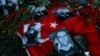 Carnations left at the scene around photo of victims as people protest an attack at a popular nightclub in Istanbul, Jan. 3, 2017. 