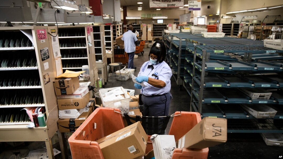 FILE - A United States Postal Service carrier sorts mail to be delivered before she sets out on her route in Philadelphia, Pennsylvania, May 6, 2020. 
