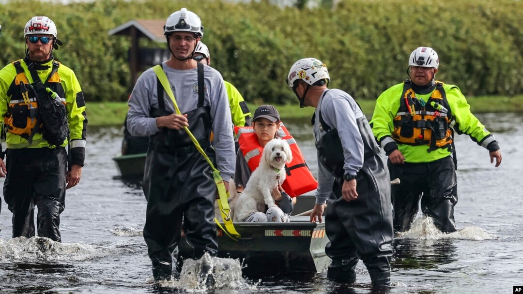 Amy Bishop es evacuada de su casa por bomberos y rescatistas mientras las aguas suben en su vecindario después de que el huracán Milton provocara la inundación del río Anclote, el 11 de octubre de 2024, en New Port Richey, Florida.