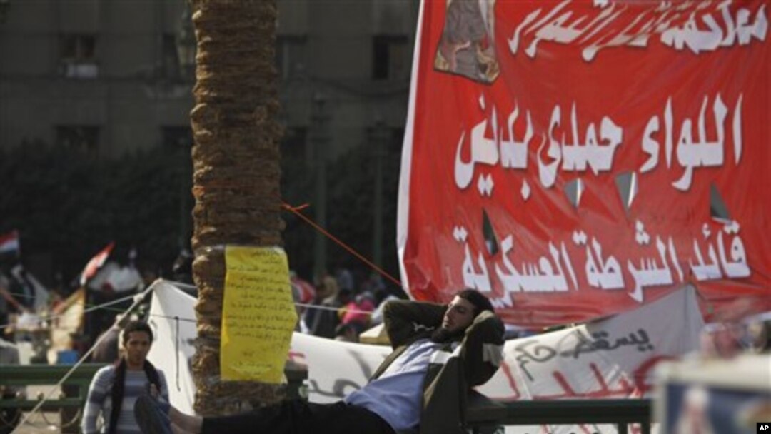 An Egyptian man rests on a fence in Tahrir Square in Cairo, Egypt, Sunday, Nov. 27, 2011. Egypt's activists are staging a massive protest in Cairo's Tahrir Square to press demands for the country's military rulers to step down. The Sunday rally, dubbed "L