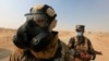 Iraqi forces wear protective masks after winds brought fumes from a nearby sulfur plant set aafire by IS militants, in Qayyara, Iraq, Oct. 22, 2016. Fears are mounting that the jihadist group, in its fight for Mosul, would not hesitate to use chemical weapons.