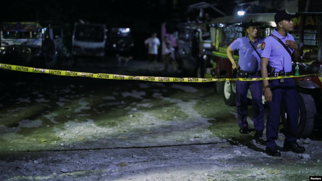 Police officers stand behind a police line after a man was killed during a police anti-drug operation in Caloocan city, Metro Manila, Philippines, Aug. 17, 2017.