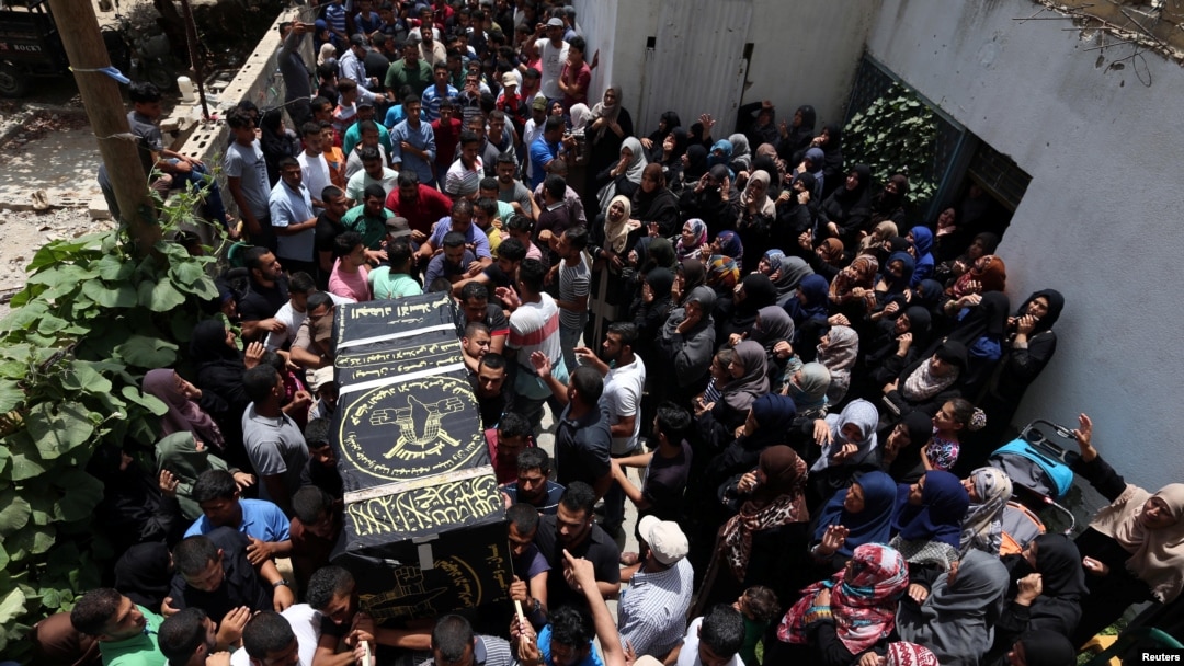 Mourners carry a casket containing the body of a Palestinian Islamic Jihad militant, who was killed in Israeli tank shelling, during his funeral in the southern Gaza Strip, May 27, 2018. 