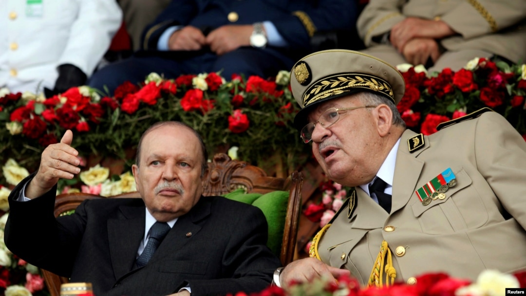 FILE - Then-Algeria's President Abdelaziz Bouteflika gestures while talking with Army Chief of Staff Lt. Gen. Ahmed Gaed Salah during a graduation ceremony at a military academy in Cherchell, west of Algiers.