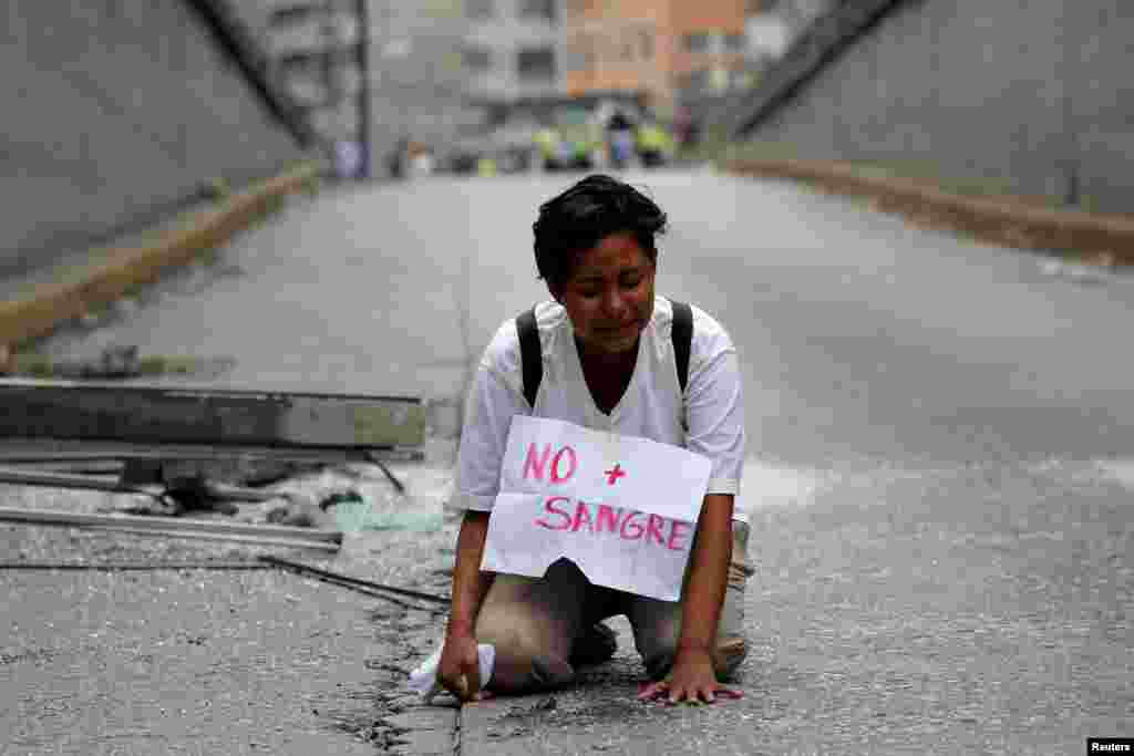 A woman cries at the site where 17-year-old demonstrator Neomar Lander died during riots at a rally against Venezuelan President Nicolas Maduro's government in Caracas, Venezuela.