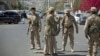 Shi'ite Yemeni Houthi, wearing army uniforms stand guard on a street leading to the presidential palace in Sana'a, Jan. 21, 2015.