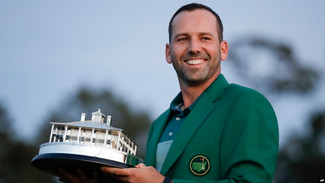Spain's Sergio Garcia holds the first-place trophy while wearing the winner's green jacket after taking after Masters' title in a playoff, April 9, 2017, in Augusta, Georgia.