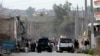 Security officials investigate the scene of a suicide car bomb attack, which killed and injured several people at the National Directorate of Security in Jalalabad, Afghanistan, February 24, 2013. 