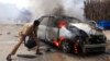 A man tries to extinguish a burning car after it exploded near Hamaerweyne market in Mogadishu, Somalia, July 24, 2013. 