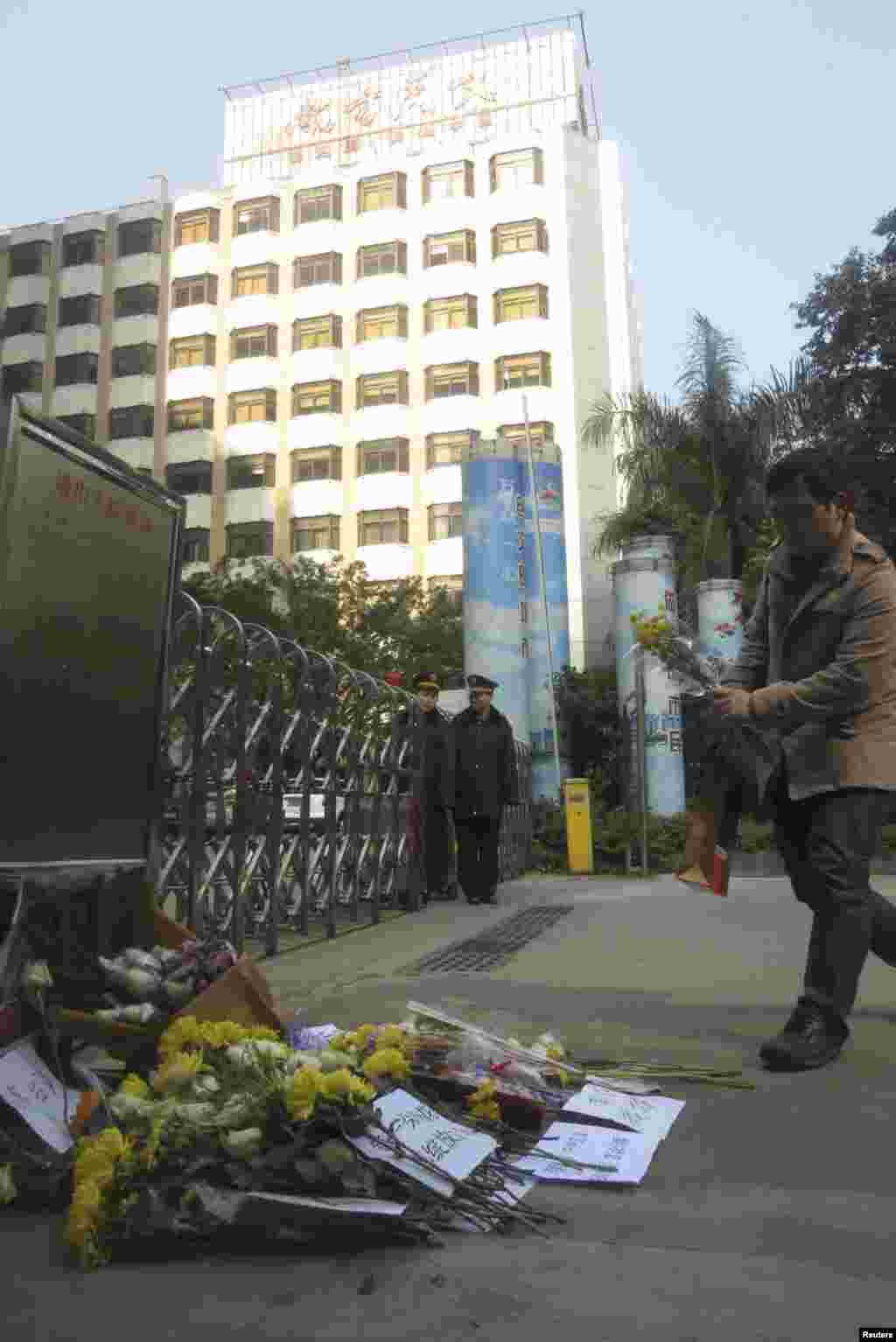 2013年1月7日,一个人在《南方周末》总部前面安放一束菊花。