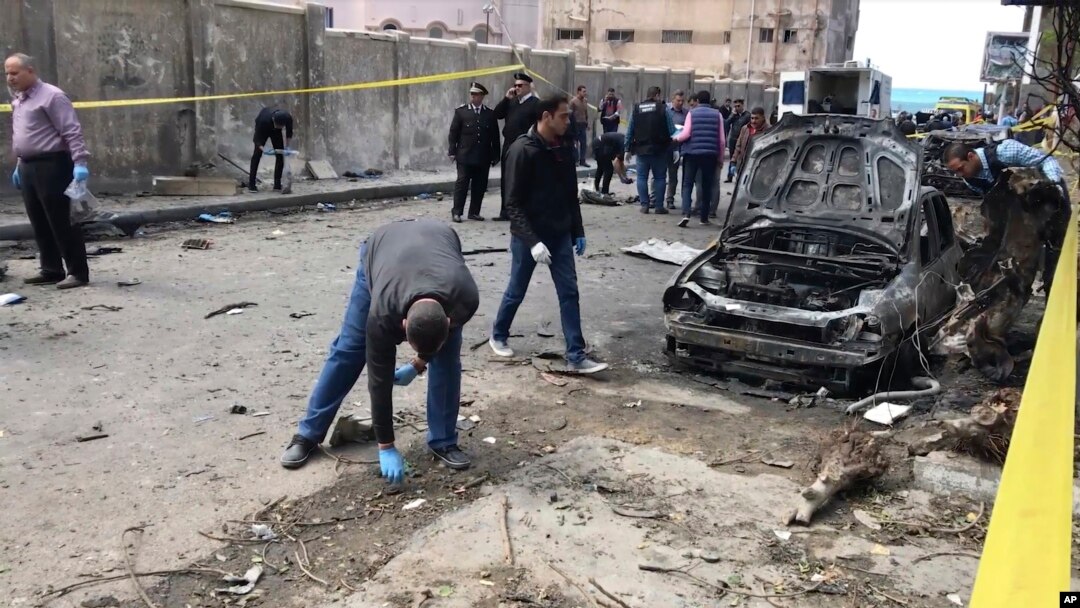 Investigators search the area after a bomb placed under a car exploded, in Alexandria, Egypt, March 24, 2018.