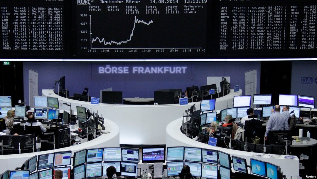 Traders are at their desks in front of the DAX board at the Frankfurt stock exchange, Aug. 14, 2014.