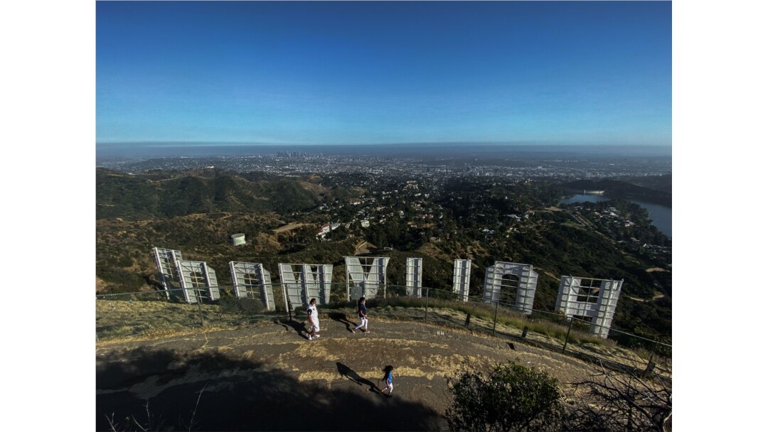 In this file photo taken on May 24, 2020 a family wearing face masks, hike at Griffith Park at the back of the Hollywood sign during the novel Coronavirus, COVID-19, pandemic in Los Angeles, California.