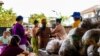 This picture taken on June 7, 2021 shows people queueing to receive food donations in a camp for displaced people in Namkham township in Shan state in eastern Myanmar.