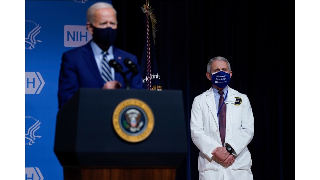 President Joe Biden speaks during a visit to the National Institutes of Health, Feb. 11, 2021, in Bethesda, Md. Dr. Anthony Fauci, director of the National Institute of Allergy and Infectious Diseases, listens at right.