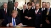 President Donald Trump signs a presidential memorandum imposing tariffs and investment restrictions on China in the Diplomatic Reception Room of the White House, March 22, 2018, in Washington. 