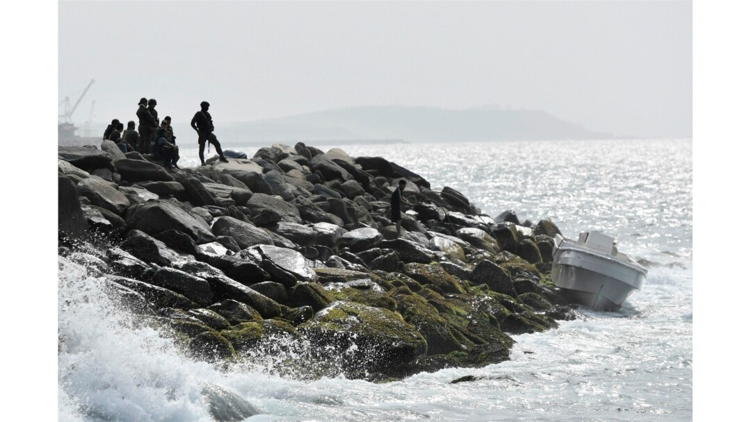 Security forces guard the shore area and a boat in which authorities claim a group of armed men landed in the port city of La Guaira, Venezuela, May 3, 2020.