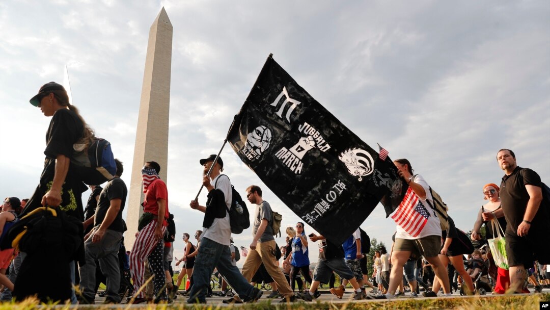Juggalos, as supporters of the rap group Insane Clown Posse are known, march past the Washington Monument as they head towards the Lincoln Memorial in Washington during a rally, Sept. 16, 2017. 