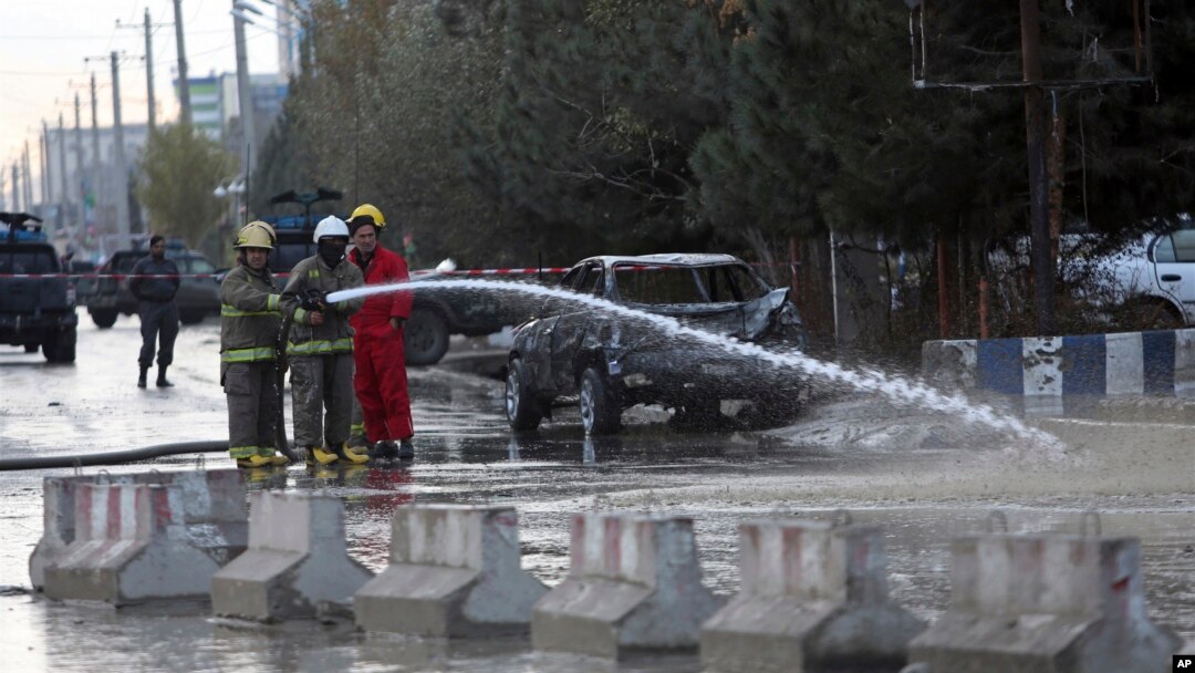 Afghan firefighters clean up the site of a deadly suicide bombing, in Kabul, Afghanistan, Nov. 16, 2017. 