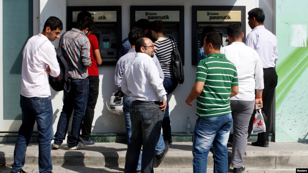 People line in front of automated teller machines in Hatay, Turkey, May 17, 2013. 