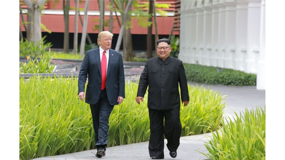 FILE - North Korea's leader Kim Jong Un walks with U.S. President Donald Trump at the Capella Hotel on Sentosa island in Singapore, in this picture taken June 12, 2018, and released from North Korea's Korean Central News Agency.