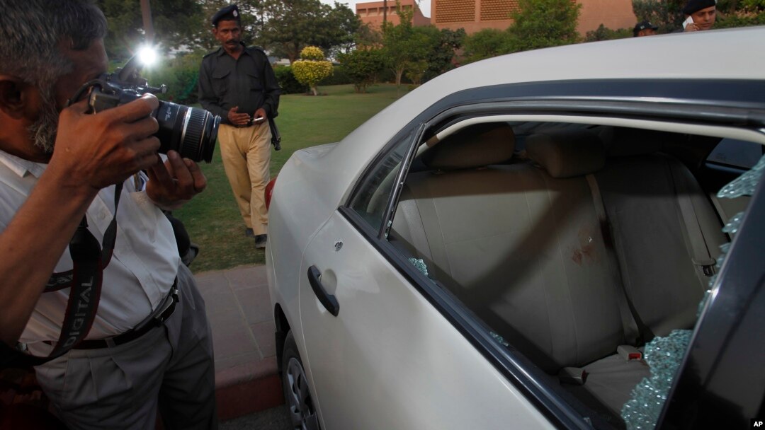 A Pakistani photographer takes photos of a bullet-riddled car belonging to journalist Hamid Mir parked at a local hospital in Karachi, Pakistan, April 19, 2014. 
