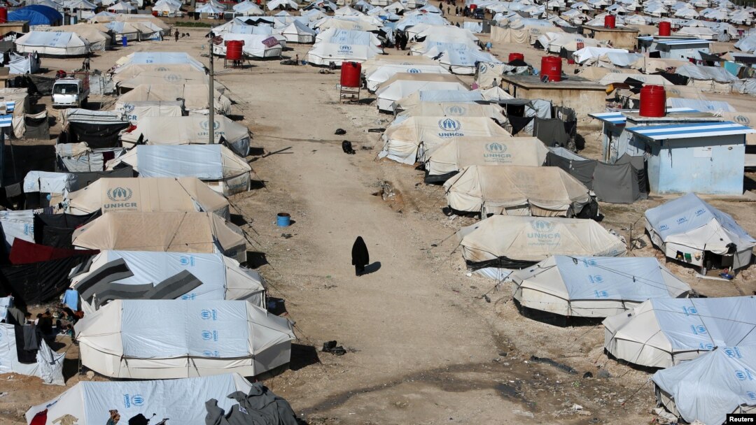 FILE - A woman walks through al-Hol displacement camp in Syria April 2, 2019.
