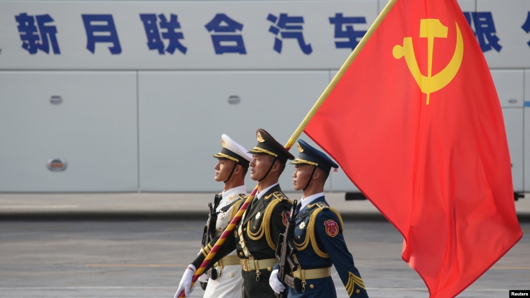 FILE - Soldiers of People's Liberation Army march in formation with a Chinese Communist Party flag during a rehearsal before a military parade marking the 70th founding anniversary of People's Republic of China, in Beijing, China, Oct. 1, 2019.
