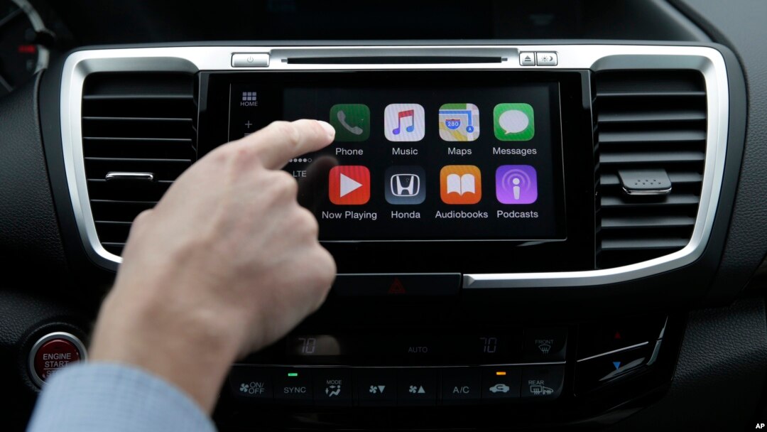 FILE - Chris Martin from Honda North America demonstrates Apple CarPlay, which lets drivers use an iPhone and its voice-activated assistant, Siri, to operate some of their vehicle’s electronic controls and entertainment systems, in Torrance, Calif., August 20, 2015.