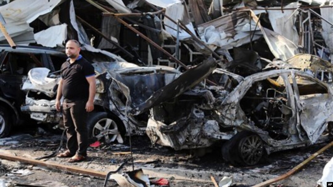 Man inspects site of car bomb explosion in Baghdad's eastern Mashtal neighborhood, Iraq, Nov. 17, 2014.