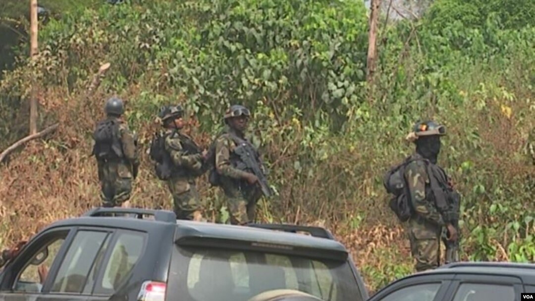 FILE - The military stands guard as government officials visit Lebialem, in southwest Cameroon, Sept. 15, 2018. Three village chiefs from Lebialem were murdered Feb. 13, 2021, by suspected rebels. 
