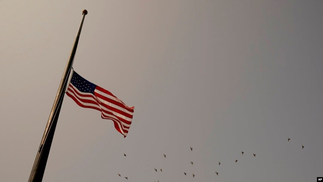 FILE - An American flag flies at half-staff.