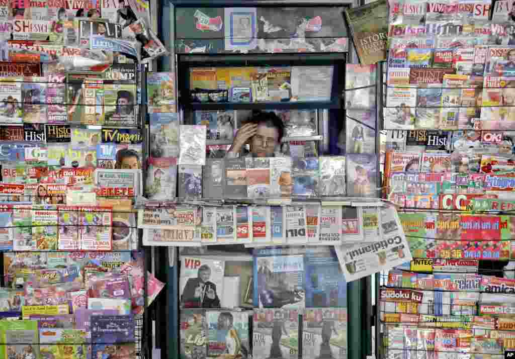 A vendor sells newspapers and magazines in a kiosk at the main railway station, Gara de Nord, in Bucharest, Romania.