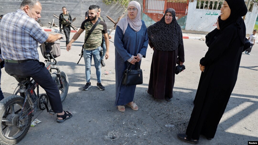 Local residents inspect an impact crater at the site of an Israeli drone strike that killed three Palestinians, on the day of their funeral at Jenin refugee camp in the Israeli-occupied West Bank Oct. 25, 2023. 