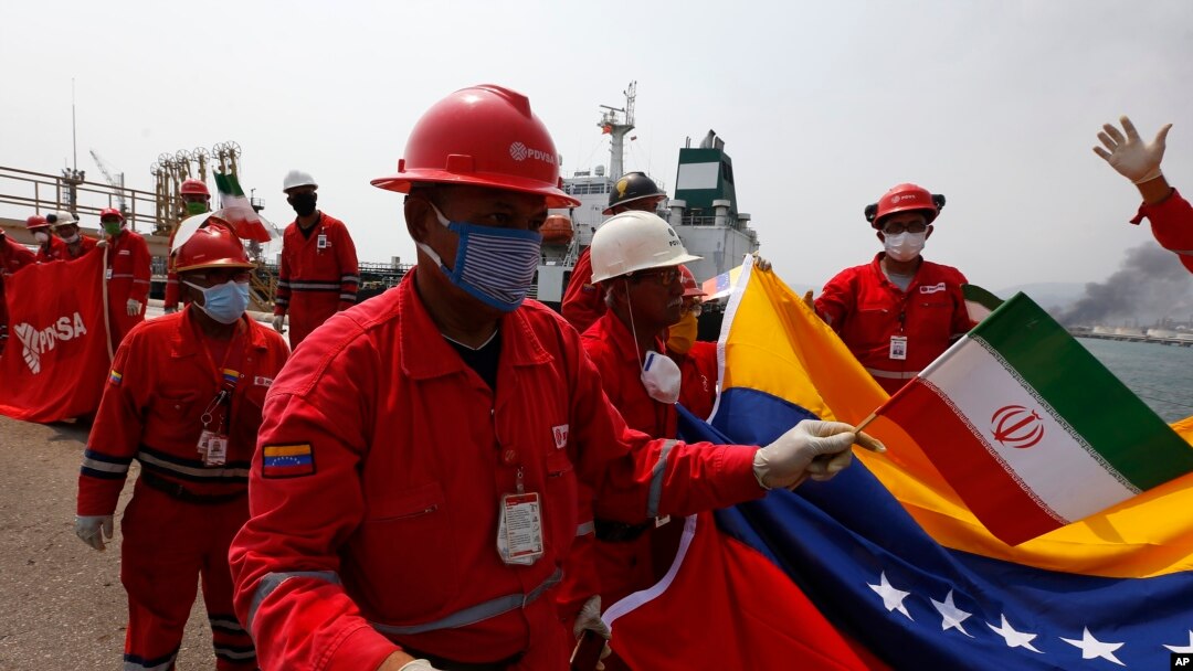A Venezuelan oil worker holding a small Iranian flag attends a ceremony for the arrival of Iranian oil tanker Fortune at the El Palito refinery near Puerto Cabello, Venezuela, May 25, 2020. 