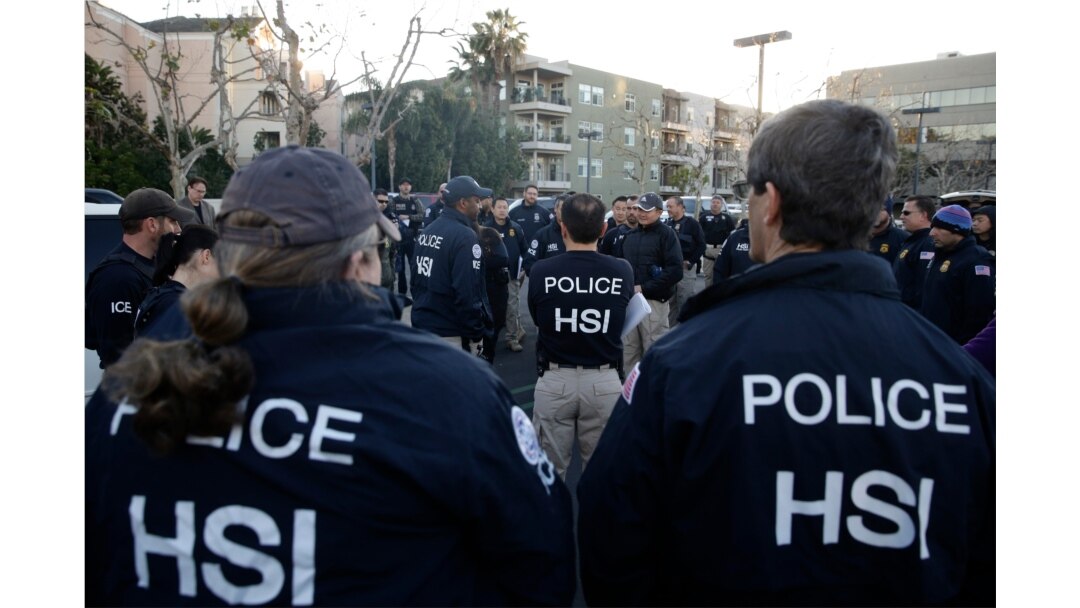 Federal agents gather at an apartment complex, March 3, 2015, in Irvine, Calif. Shortly after sunrise, agents swarmed the complex where authorities say a birth tourism business charged pregnant women $50,000.