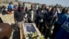 Mineworkers pray over the coffin containing the body of Mpuzeni Ngxande, one of the 34 striking miners that were killed by police on August 16, in front of the rocky outcrop where the men were shot, an informal settlement near the Lonmin mine in Marikana,