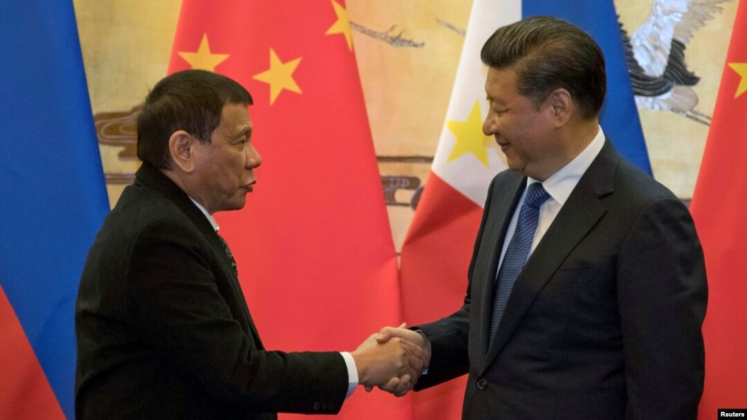 FILE - Philippine President Rodrigo Duterte (L) and Chinese President Xi Jinping shake hands after a signing ceremony held in Beijing, Oct. 20, 2016. 