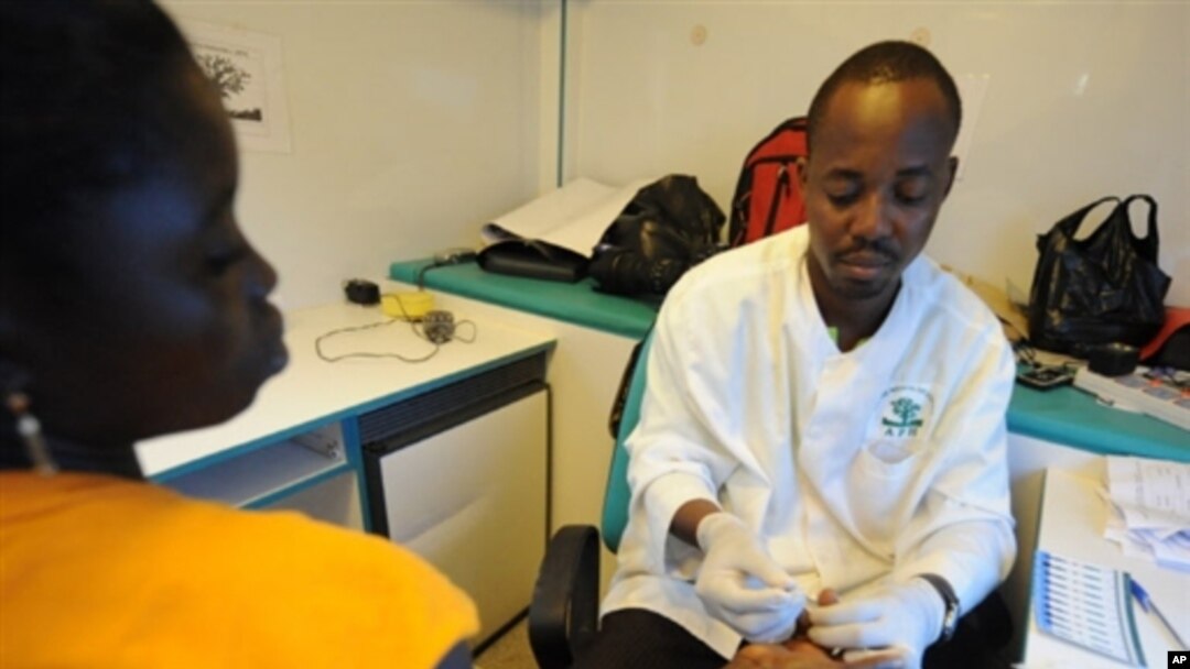 A volunteer health worker retrieves blood sample for an HIV-AIDS detection test on a patient on 18 Jun 2008 in Noe, a city in Ivory Coast close to the Ghana border