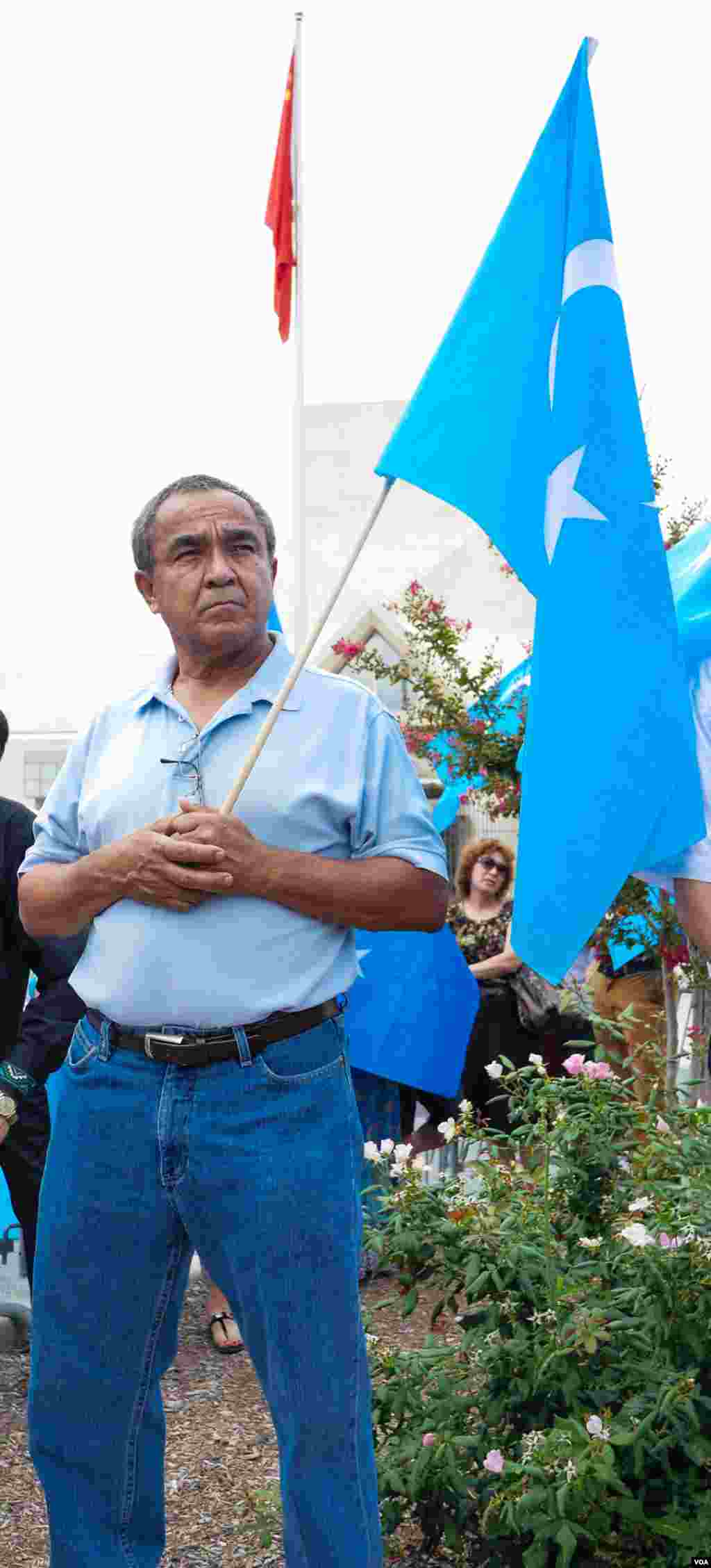 Uyg'urlar Sharqiy Turkiston bayroqlarini ko'tarib, Xitoy elchixonasi qarshisida bu davlatning uyg'urlarga qarshi siyosatini qoralab, namoyish qilmoqda, Vashington, 3-avgust, 2014-yil. Odil Ruzaliev surati