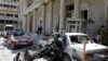 Security personnel walk in front of the former Interior Ministry building after a blast at Marjeh Square in Damascus, Syria, Apr. 30, 2013.