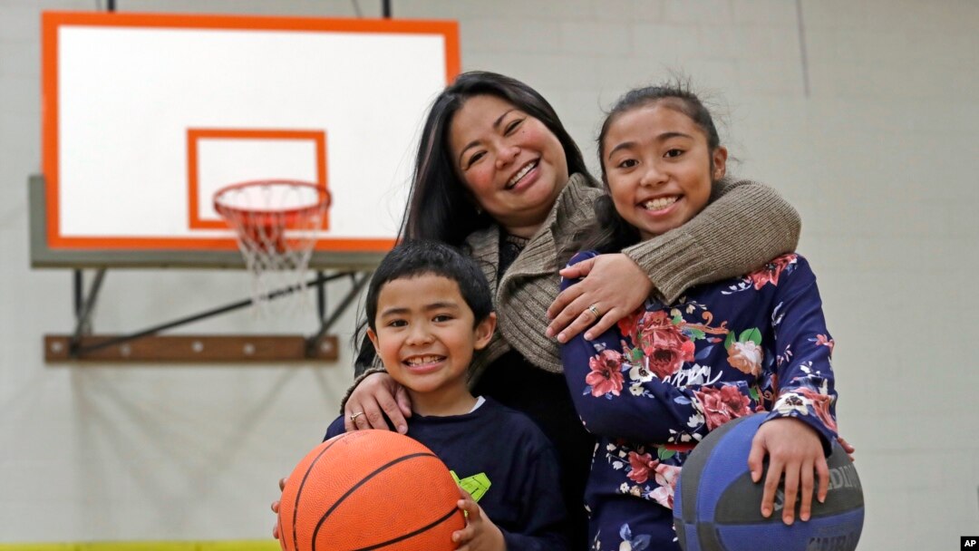  Lara Mae Chollette, a coach of youth soccer and basketball, poses for a photo with her son Jaylen, 7, left, and daughter Linda, 10, at a community gym in Seattle.
