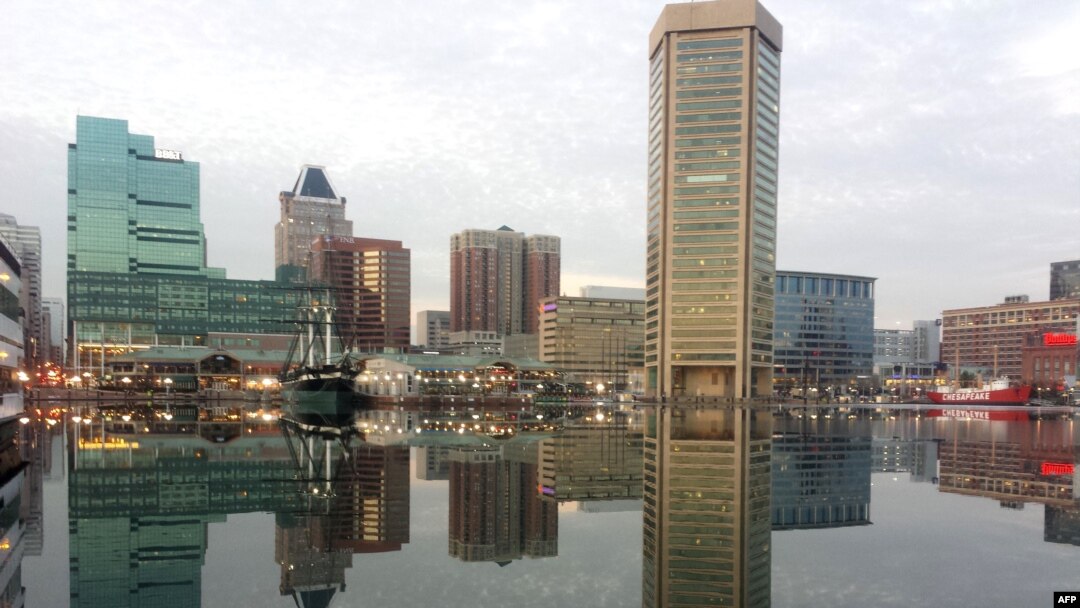 FILE - Baltimore, Maryland, is reflected in a still and icy Inner Harbor, Jan. 31, 2014. 